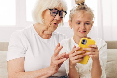 Video uzay aile telefonu bağlanma gülümseme kapalı eğitim beyaz selfie fotoğraf tişörtü büyükanne iki çocuk birlikte torun kucaklama kanepesi denir