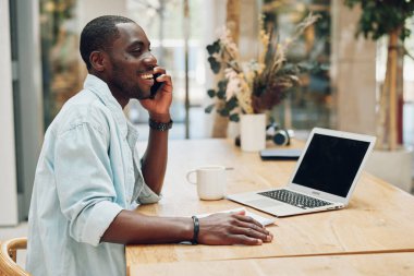 Çalışan, zenci, mutlu, profesyonel iş adamı, modern, bilgisayar işi, iş adamı, teknoloji ofisi, yaşam tarzı, dizüstü bilgisayarlı telefonlardan bahsediyor.