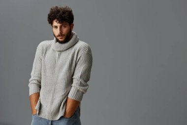Moda tarzı yakışıklı adam portre modeli süveter giyiyor sakallı, beyaz, beyaz, çekici, kendine güvenen bir stüdyo çocuğu.