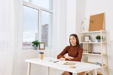 Masa başı öğrencisiyse içeride genç bir ofiste oturuyor. Not defteri hazırlıyor. Sınav okulu öğrencisiyse e-öğrenim gören üniversite öğrencisi.