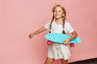 Aktif Yaşam Tarzı: Parlak Pembe Penny Tahtasında Sevimli Küçük Kız Kayıyor