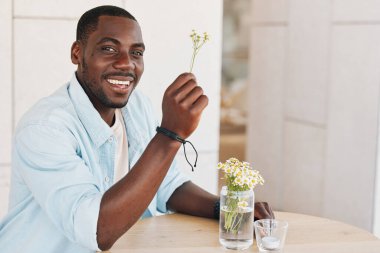 Neşeli, mutlu, Amerikalı, çekici, kendine güveni olan, Afrikalı, başarılı, rahat, sağlıklı, genç, siyah ev portresi çizen bir adam.