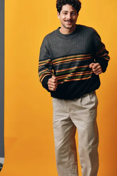 Man smile student model portrait guy beard sweater studio background modern caucasian male cool orange trendy serious happy young adult person thinking natural fashion