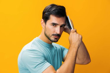 Yaşam tarzı erkek portresi yakın plan sarı taraklı saç bakım berberi güzel görünümlü saç fırçası, sakal fırçası, saç fırçası kaybı, stüdyo yakışıklı arka plan saçı.