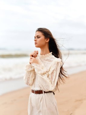 Yaz Güzelliği: Uzun Esmer Saçlı Genç Çekici Kadın, Sandy Sahilinde Rahatlıyor, Okyanus Esintisinin tadını çıkarıyor