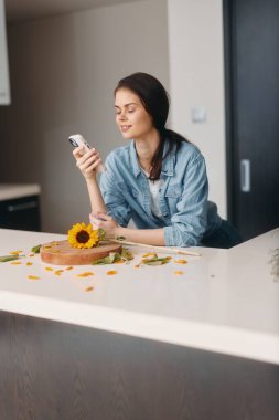 Gelişigüzel Mutfakta Akıllı Telefon Kullanan, Sağlıklı Kahvaltı Yapan Şık Kadın