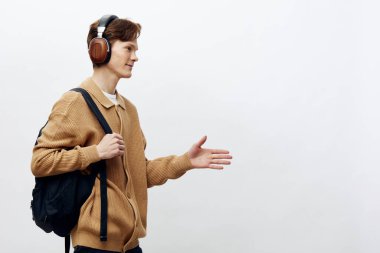 Kulaklıklı ve sırt çantalı genç bir adam.