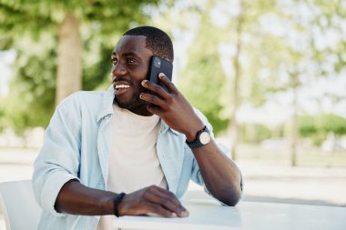 Yetişkin bir adam cep telefonuyla konuşuyor yakışıklı bir erkek mutlu bir portre siyah bir hayat tarzı telefon modern neşeli bir gülümseme