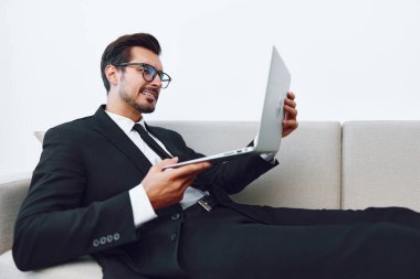 Hunk man kanepe izleme oturan girişimci gülümseyen başarı yalan iletişim kanepede laptop online adam video serbest çalışma profesyonel iş evi aramak ağ çalışma ev çekici