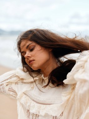 Güneşle Öpülmüş Güzel: Büyüleyici Kadın Modeli Serene Beach Sunset 'in tadını çıkarıyor Beyaz Elbiseli, Esmer ve Parlak Gülüşlü.