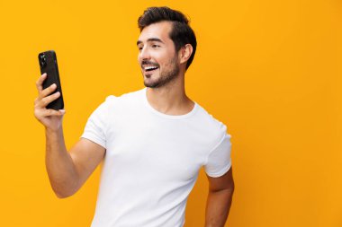 Telefoncu iş teknolojisi gülümseyen akıllı telefon uzay gözlüğü mutlu cep telefonu sarı sürpriz gülümseme mesaj dolu telefon yaşam tarzı siber uzay portresi izole edilmiş stüdyo görüntülerine işaret ediyor.