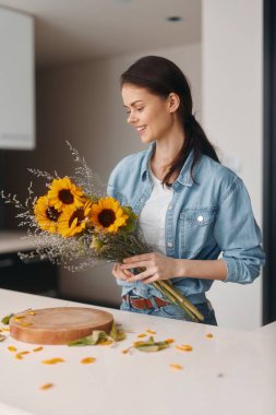 Çiçek Güzeli: Genç, Çekici Kadın Çiçekçi Mutfak Masasında Taze Buket ile Evde Çalışıyor