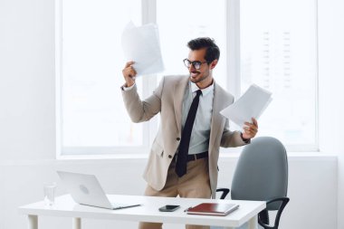 Kurumsal adam iş adamı profesyonel kağıt planlama mutlu şirket yönetici yönetici kişi çalışan genç belge gülümseyen dizüstü bilgisayar yöneticisi ofis takım elbise iş