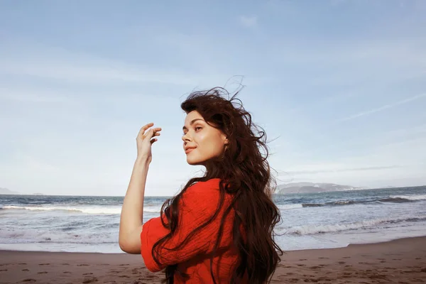 Smiling Woman Enjoying Freedom and Joy at the Beach: A Portrait of a Happy, Young Lady with Red Clothes