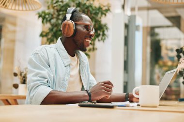 Kulaklık dinleyen adam bilgisayar yaşam tarzı gündelik yakışıklı iş adamı online modern müzik sektörü genç teknoloji adamı erkek kulaklıklar yetişkin dizüstü bilgisayarlar.