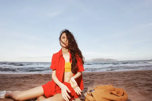 Joyful Explorer: A Young Woman Backpacking in Nature, Relaxing at a Beautiful Seaside Beach.