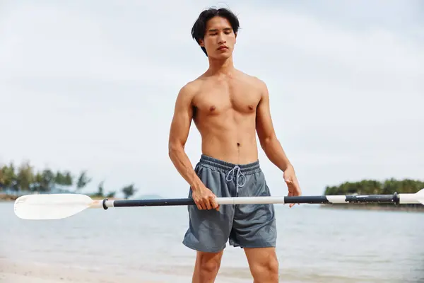 サマービーチでパドルボーディングアドベンチャーを楽しむアクティブなアジア人男性 — ストック写真