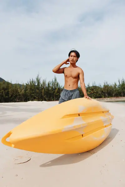 トロピカルビーチでハッピーなアジア人男性カヤック アクティブな夏休みを楽しむ — ストック写真