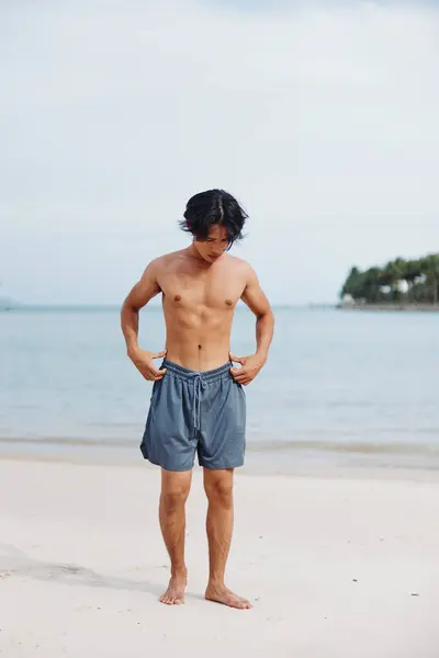 サンセットでビーチでカーディオトレーニングを楽しむ筋肉アジア選手 — ストック写真