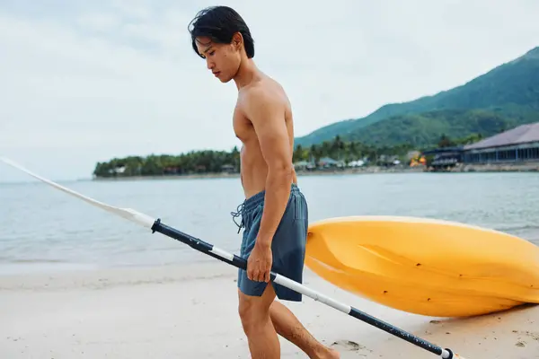 トロピカルビーチでハッピーなアジア人男性カヤック 夏休みを楽しむ — ストック写真