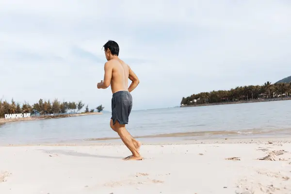 サンセットでビーチでアウトドアフィットネストレーニングを楽しむ筋肉アジアの選手 — ストック写真