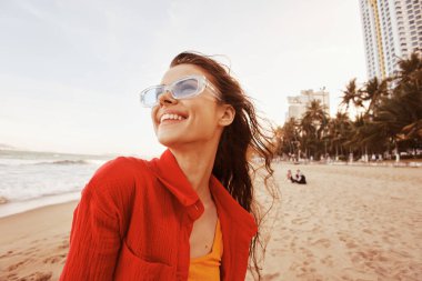 Deniz kenarındaki gülümseyen kadın, Özgürlük ve Yaşam tarzını kucaklıyor.