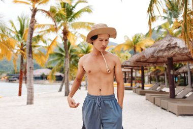 Mutlu Asyalı Adam Tropikal Sahilde Yaz Tatilinin keyfini çıkarıyor