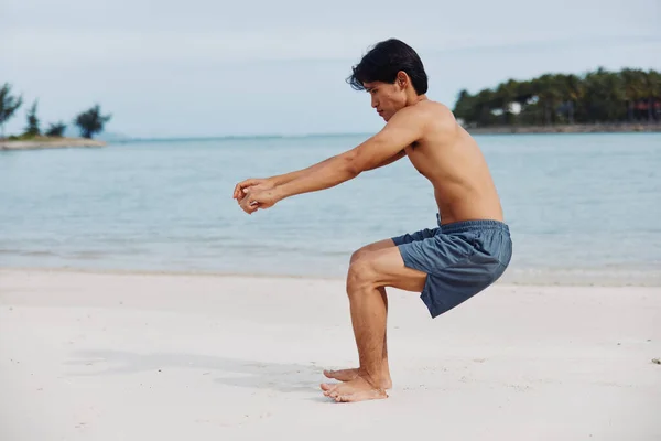 ビーチの自由を受け入れる筋肉アジアの選手 サンセットで砂の上を走っている間に健康的なライフスタイルを取り入れる強いフィットマンの肖像画 — ストック写真