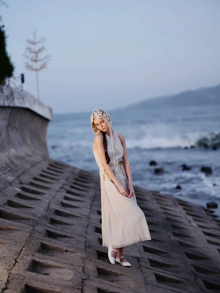 Sun-kissed Serenity: A Young, Attractive Lady in a White Dress, Enjoying a Romantic Summer Vacation on a Beach, Embracing the Beauty of Nature and the Tranquil Blue Ocean at Sunset