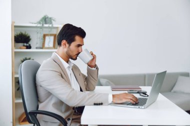 Kapalı alanda gülümseyen dizüstü bilgisayar yöneticisi kahve patronu masa başı internet yöneticisi beyaz kurumsal yazıcı erkek bilgisayar ofis video iş adamı