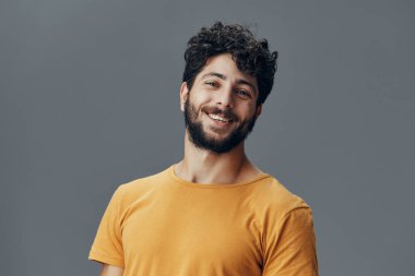 Kendine güvenen bir stüdyo adamı beyaz gülüşlü, mutlu, izole edilmiş, pozitif bir insan arka planı neşeli, genç moda ifadesi çekici, sıradan, yakışıklı bir yetişkin.