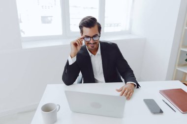 Mutsuz masabaşı düşünen, gözlüklü, üzgün, iş sahibi, yönetici, takım elbiseli, sinirli ofis çalışanı, yetişkin, kafası karışık, dizüstü bilgisayarı olan bir adam.