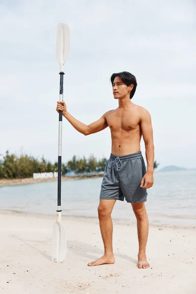 ビーチアドベンチャー パドルボードでのアクティブなアジア人男性のエクササイズ サマー楽しさとサンセットで海の波をサーフィン — ストック写真