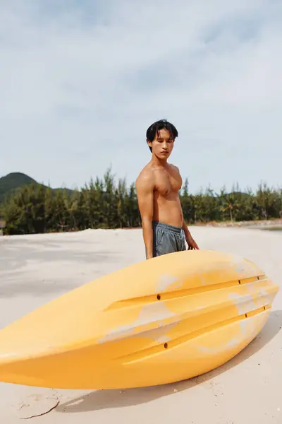 トロピカルビーチでカヤックアドベンチャーを楽しむ幸せなアジア人男性 — ストック写真