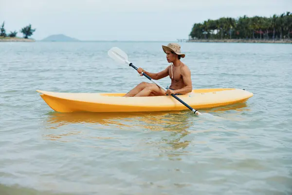 トロピカルビーチでカヤックアドベンチャーを楽しむアクティブなアジア人男性 — ストック写真