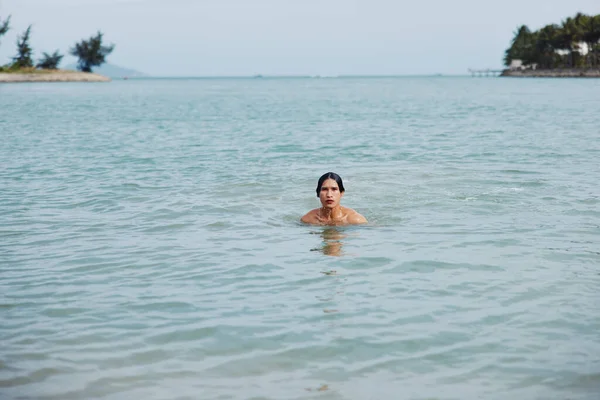 トロピカルビーチでリフレッシュスイミングを楽しむ笑顔のアジア人男性 リラックスした夏休みの自由を受け入れる — ストック写真