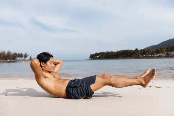 フィットネスとウェルネスのためのサンセットビーチランに参加する筋肉アジアの選手 — ストック写真
