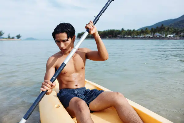 Mutlu Asyalı Adam Tropikal Sahilde Kano Macerasının Tadını Çıkarıyor — Stok fotoğraf