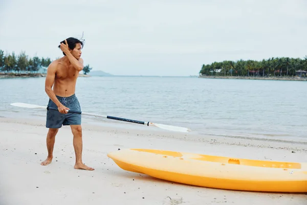 トロピカルビーチでスリリングなカヤックアドベンチャーを体験する幸せなアジア人男性 — ストック写真