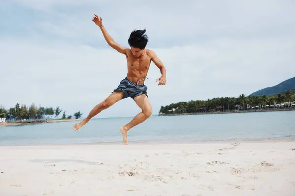サンセットでビーチでカーディオワークアウトを楽しむ筋肉アジアの選手 — ストック写真