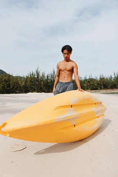 トロピカルビーチでハッピーなアジア人男性カヤック 夏休みを楽しむ — ストック写真