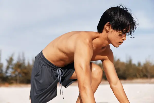 強さと自由とサンセットビーチランに参加する筋肉アジアの選手 — ストック写真