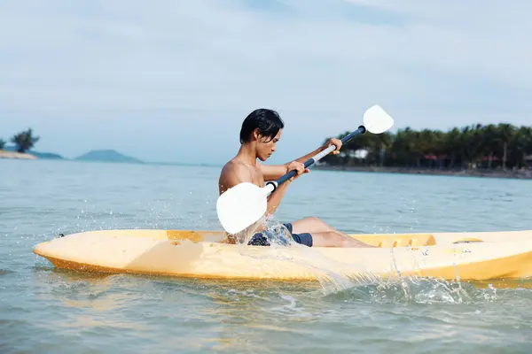 トロピカルビーチパラダイスでハッピーアジア人男性カヤック 夏休みを楽しむ — ストック写真