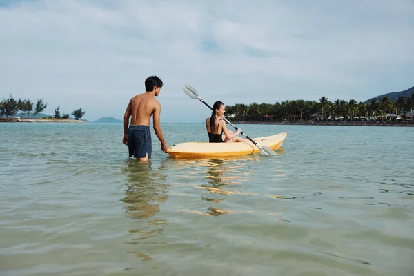 独木舟的幸福 一个与自信的亚洲女人和男人在美丽的阳光湖上享受积极休闲的宁静热带冒险 — 图库照片