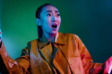 Parlak kadın güzellik neon makyaj genç Asyalı portre sarı disko kadını yüzü zarif, ince, şık, yeşil moda renkli ışık