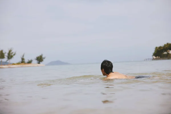 熱帯海で泳ぐ男 青空の下でアクティブなリラクゼーションと楽しい楽しい — ストック写真