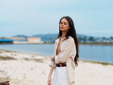 Deniz Dinginliği: Sahilde Çekici Genç Kadın Pozisyonu, Yaz Güneşi ve Mavi Okyanus Suyunun Tadını Çıkartıyor