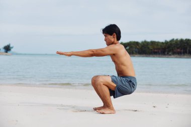 Aktif Asya Sporcusu: Günbatımında Sahilde Koşan Kaslı Adam, Enerji ve Güç Çıkarıyor
