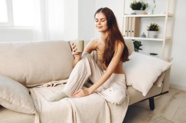 Sıcak Sonbahar Sabahı: Kahvesini İçen Gülümseyen Kadın, Battaniyeye Sarılı, Evdeki Kanepede Rahatlayan