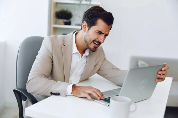 Man job manager scream businessman technology success white victory worker office laptop yes celebration business winner sitting happy professional suit